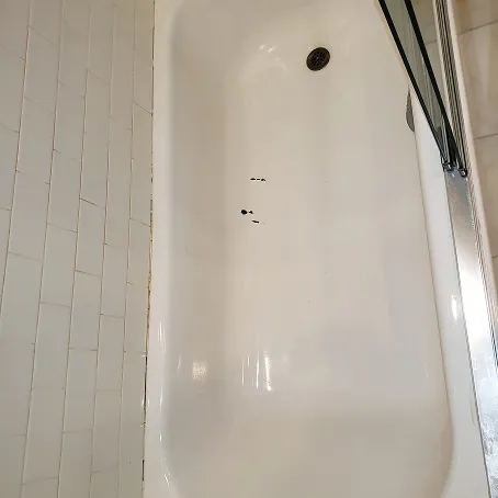 Refinished white bathtub with subway tile surround