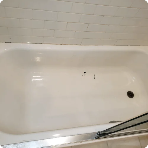 Refinished white bathtub with subway tile surround