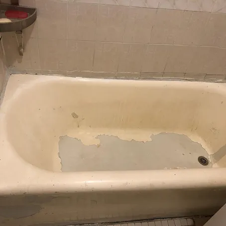 Damaged bathtub with peeling finish before refinishing