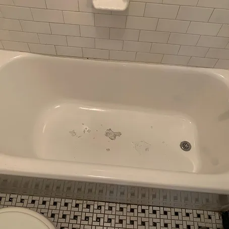 White bathtub with peeling finish before refinishing
