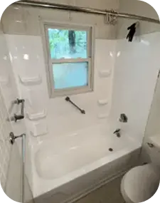 Refinished white bathtub and shower with built-in shelves and grab bar