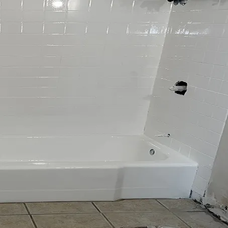 Refinished white bathtub and shower surround with glossy tile walls