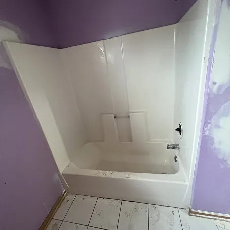 White bathtub and shower surround with smooth wall panels