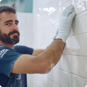 Technician applying sealant to bathroom wall tiles