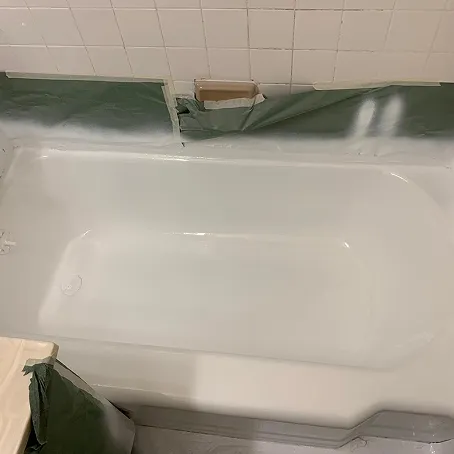 Refinished white bathtub with glossy finish and tile surround