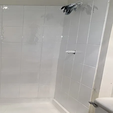 Refinished white shower surround with glossy tile walls