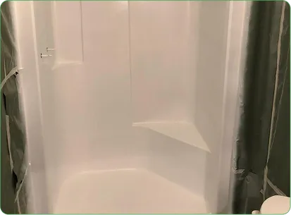 Refinished white shower stall with built-in corner shelf