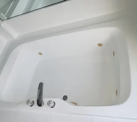 Refinished white soaking bathtub with chrome faucet