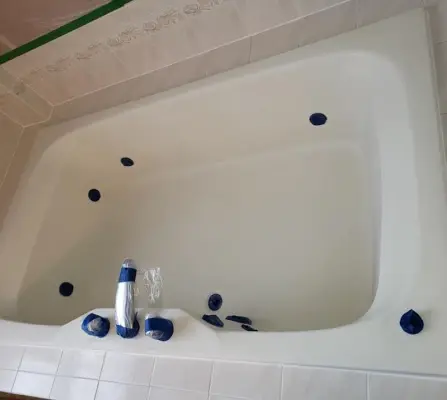 Professionally refinished white jetted bathtub with built-in whirlpool jets and a smooth glossy finish after reglazing