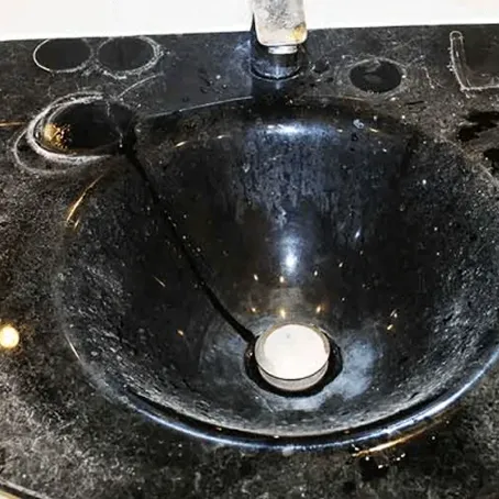 Damaged black bathroom sink before refinishing
