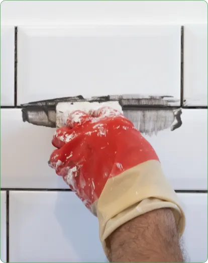 Technician applying grout to white wall tiles