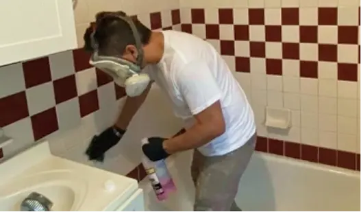 Technician preparing a bathtub for refinishing